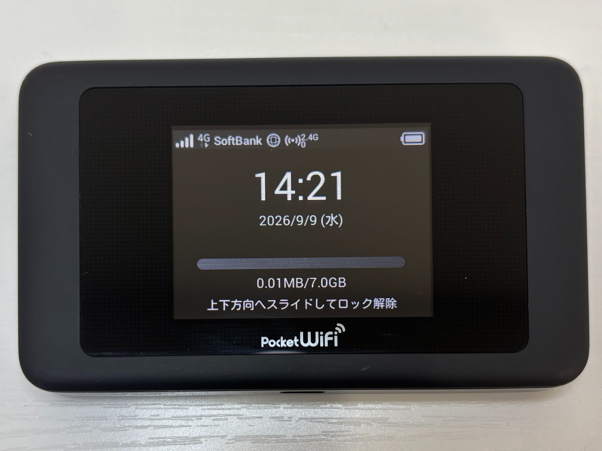 Pocket WiFi lock screen showing the clock, the date, and the data counter, with the Japanese instruction to slide up and unlock